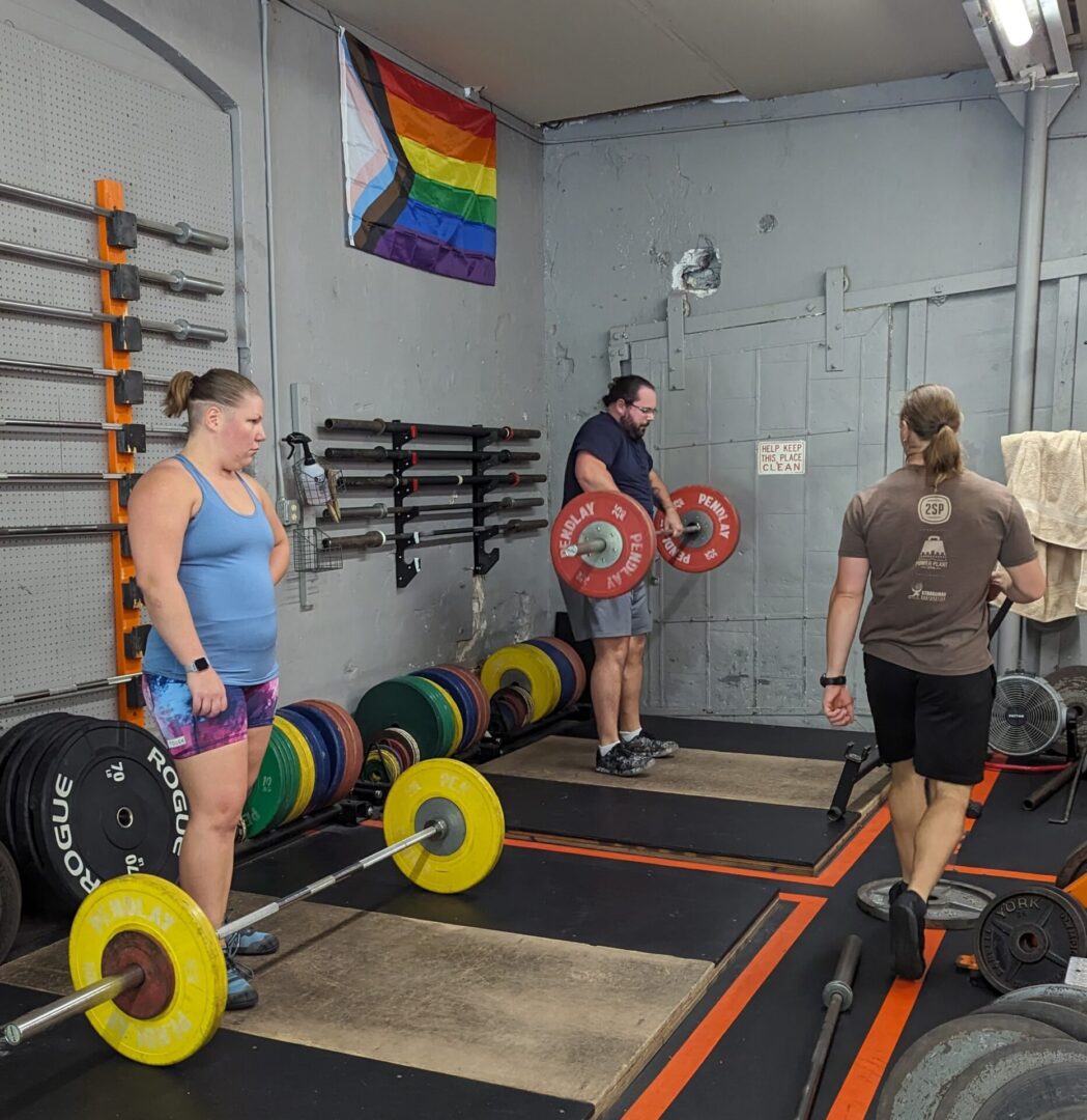 Cute couple works on learning weightlifting with trainer